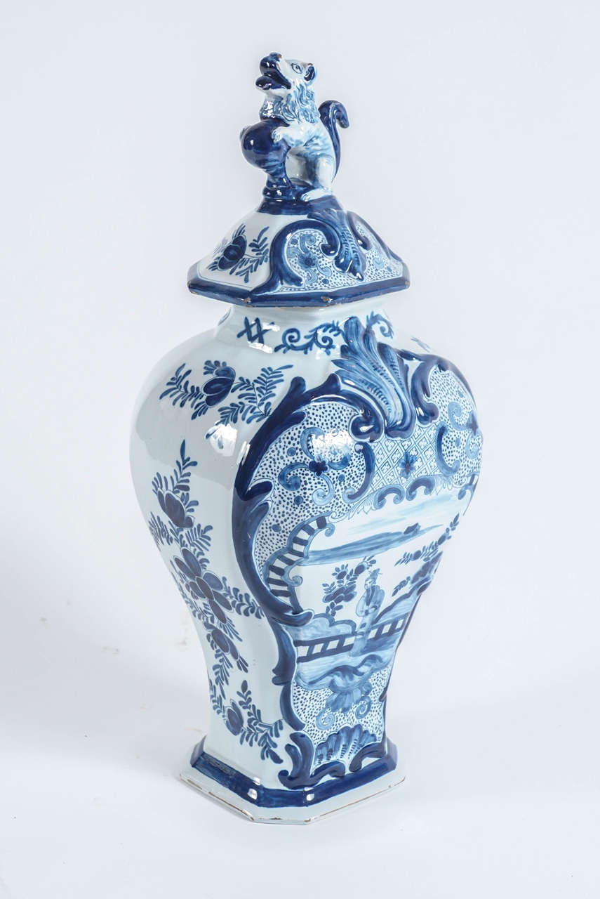 An exquisite large blue and white Delft tin-glazed pottery covered jar of baluster form having body and lid with molded Rococo ornament all with underglaze blue painted Chinoiserie motifs.  Lid with finely detailed Foo dog and ball finial. 