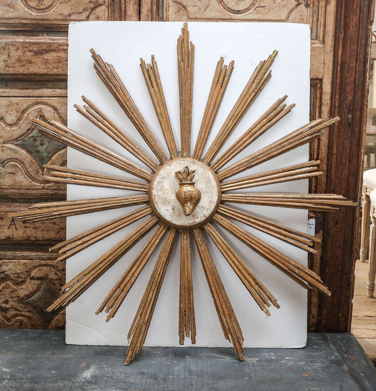 Wood carved and gilded gold sunburst with carved relief of sacred heart in the center from Portugal.