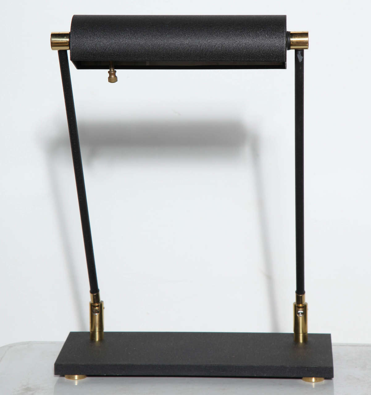 Midcentury Industrial style double pedestal and double stem Piano Lamp or Pharmacy Lamp with Black enameled articulating Shade atop a rectangular textured Black paint surface with four rounded Brass feet and textured Black articulating rheostat