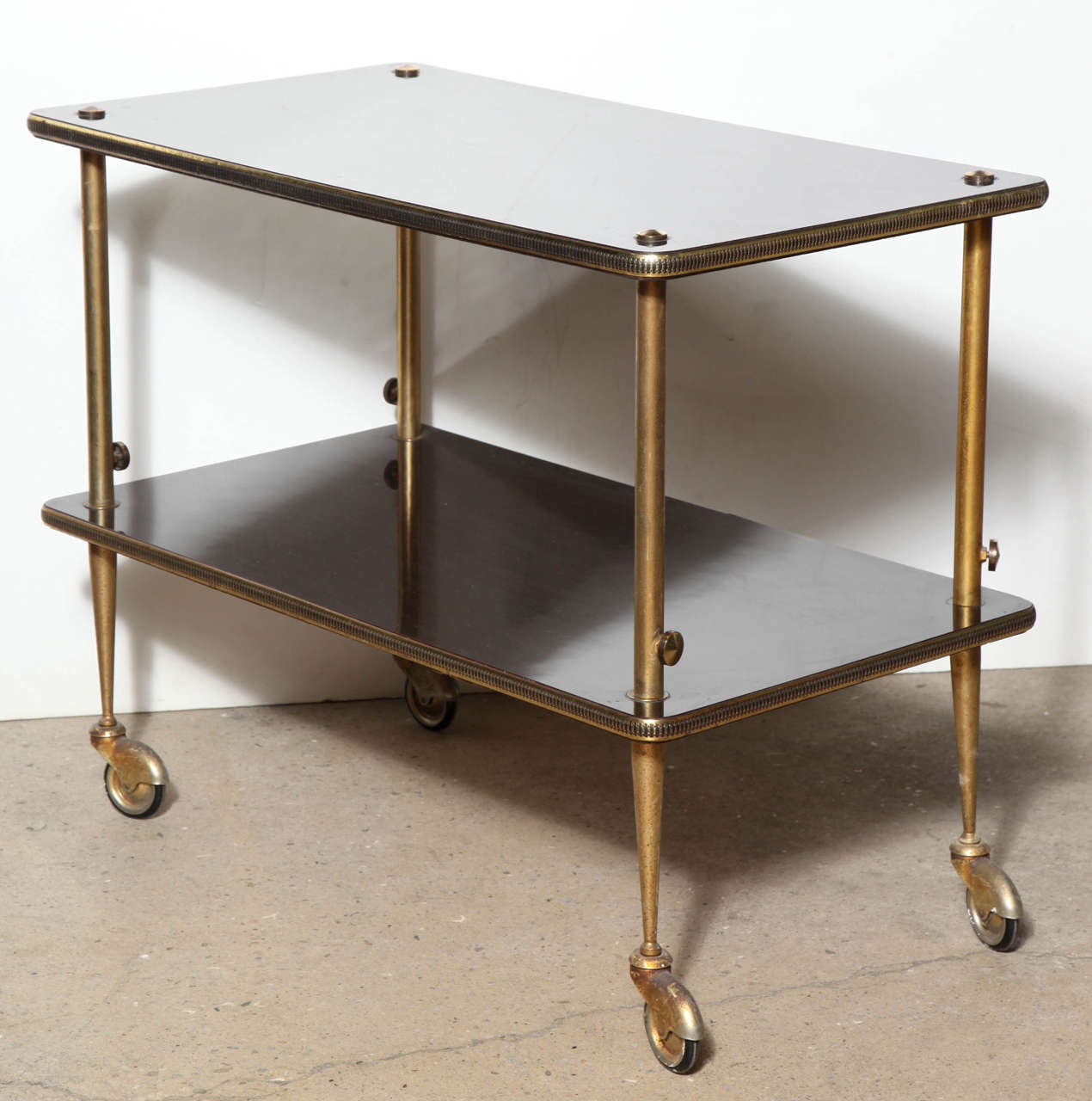 Italian Modern Rosewood and Brass rolling Coffee Cart, Tea Cart or Bar Car with Two Shelves. Each dark laminated Rosewood shelf detailed with a vertical Brass surround border, patinated Brass legs and 2.5D casters making for easy use and transport.