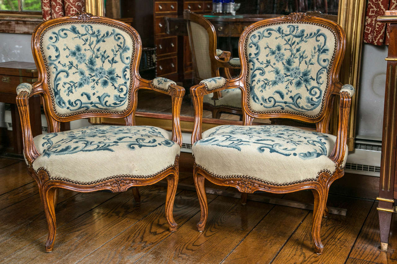 Upholstered in needlepoint, this delightful pair of fauteuil chairs in carved walnut reminds us of a time not so long ago when we took a moment to sit beside someone and have an actual conversation. Sentences were well thought out and did not