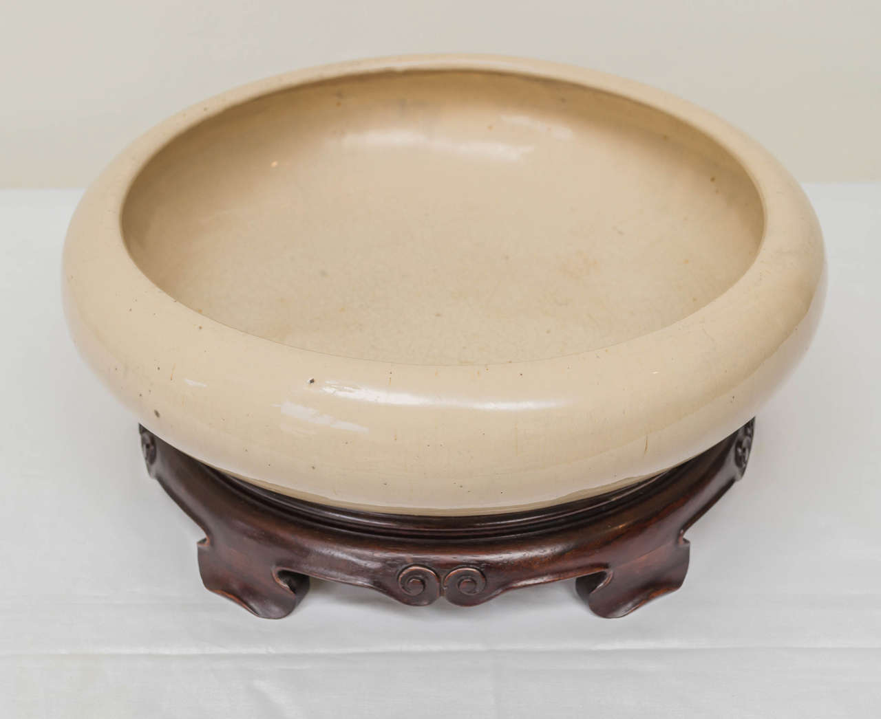 Late 19th century, Chinese large-scale bulb bowl and Stand bearing a Chien Lung mark. Unusual light tan glaze. Custom fitted detailed rosewood Stand, 11' diameter x 2