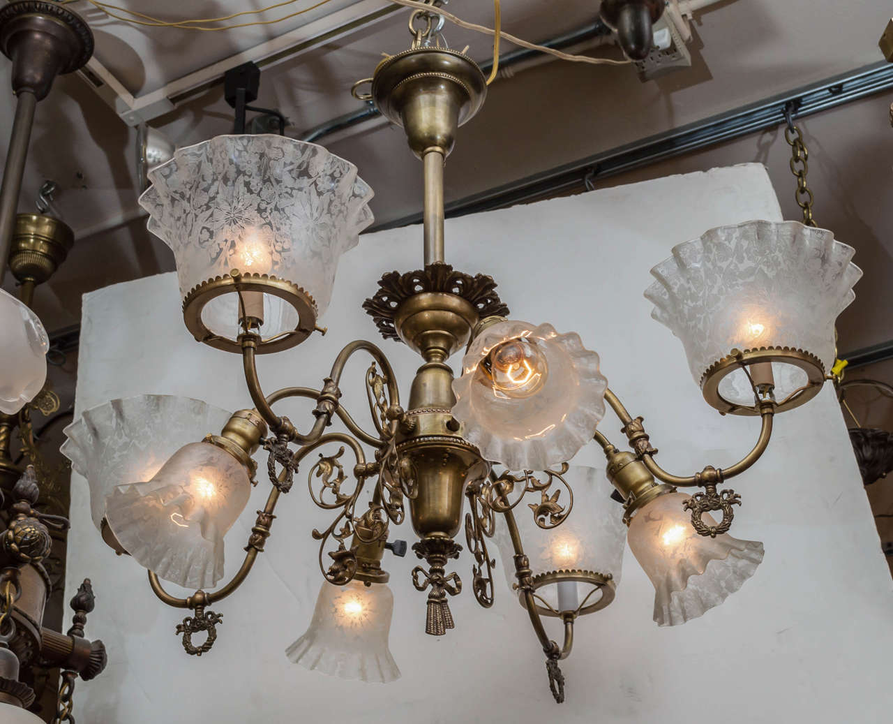 A nice example of a late Victorian chandelier. People love the combination gas and electric chandeliers, as they offer both up and down light. This chandelier has the best of the period shades that should accompany such a chandelier. The shades are