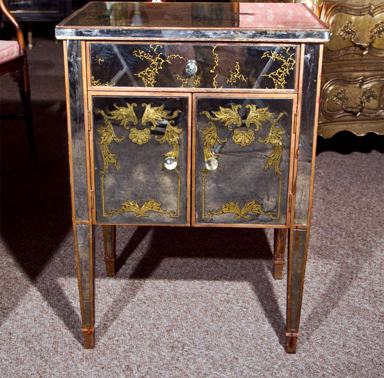 Pair of vintage French stands, each distress painted frame with eglomise glass veneer, single drawer over a two-door cabinet, raised on squared tapering legs, lucite knob pulls.

SOLD AS IS. ONE SIDE PANAL IS CRACKED.