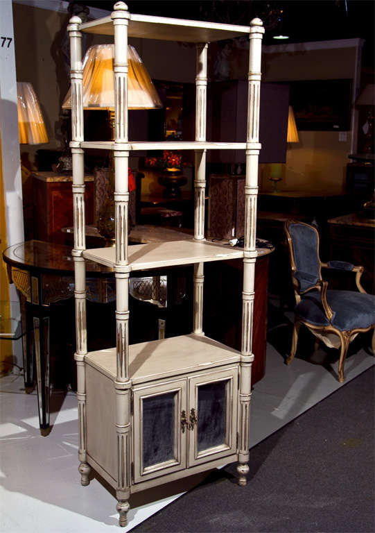 A pair of painted Swedish three-shelve étagères cupboards. Each raised on four feet supporting a pair of Mylar mirror panel doors on fluted columns with four shelving units.