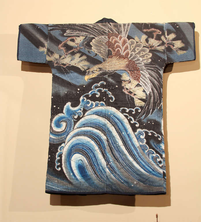 Japanese reversible fireman's coat (haten) with indigo dyed exterior and interior with tsutsu-gaki (wax resist) design of a watchful hawk (taka) perched on a pine bough with crashing waves below. Fire-fighter’s jackets were designed to retain water