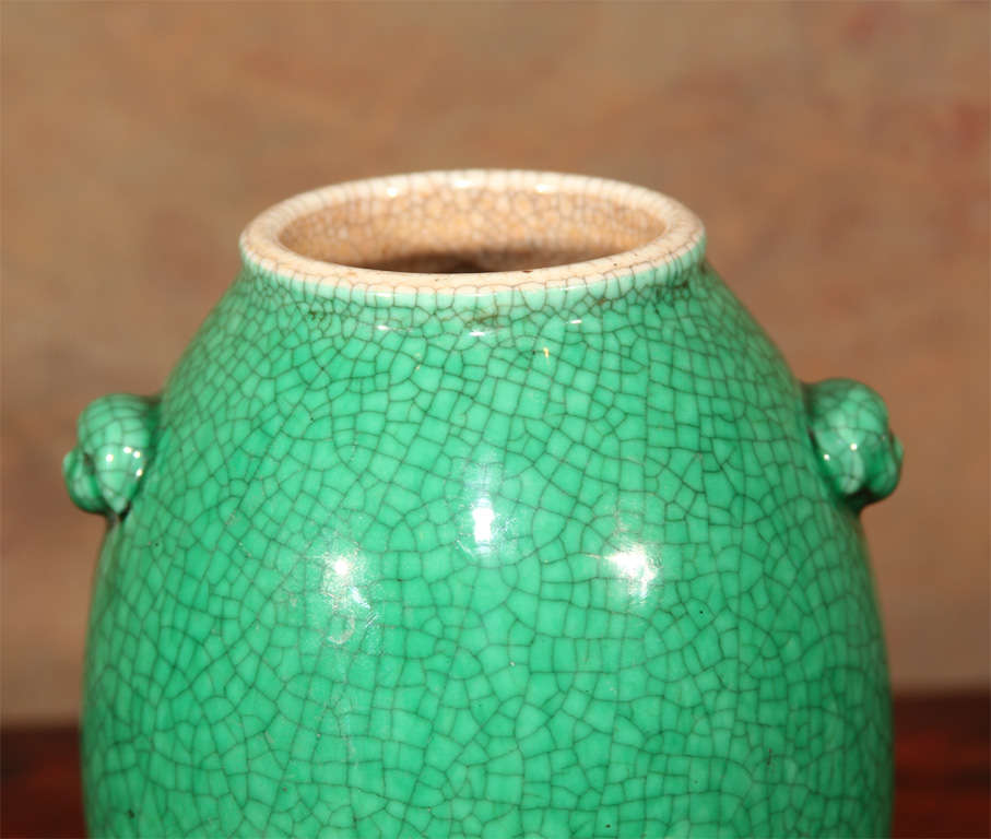 Chinese crackle glaze porcelain vase. Of bulbous form with pair of applied lion mask handles, the exterior of the vase with monochrome green enamel decoration.