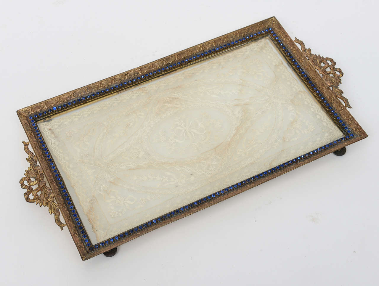 Fabulous ormolu tray with antique lace mat.  The frame is surrounded with blue stones, all original.  This may have used as a vanity tray but has many uses including purely display.  The ormolu casting is very fine, better in person and there is a