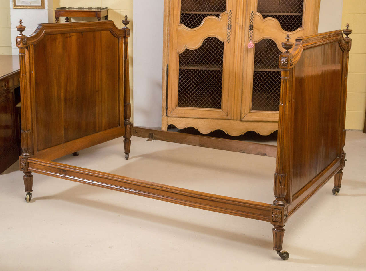 A beautiful Louis XVI style French walnut Day Bed. Each side panel has two carved columns with finials that end on castors. This Bed retains its beautiful, rich, original color and patina and has a fresh French Polish.