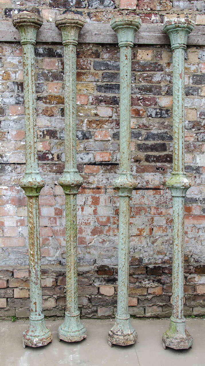 A set of four antique columns in cast iron. These Victorian columns are Gothic Revival in style and are sold in their reclaimed, weathered state. If preferred the columns could be stripped and polished to better show off the decorative