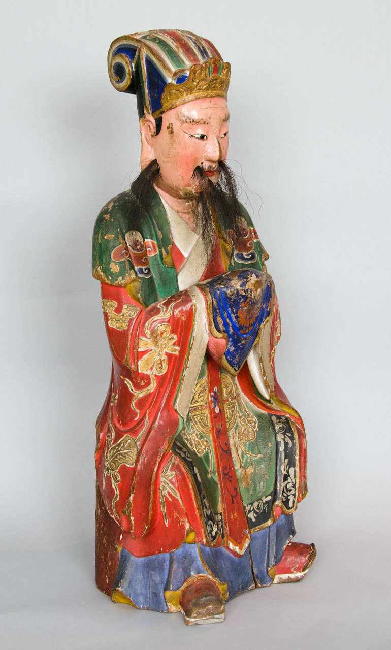 A large carved wood polychrome painted Chinese figure of a Sage dating from around 1760. South-east China. 
The back holds a cavity in which it was custom to hold small rolls of prayers.
The beard is realistically create using horse hair, the face