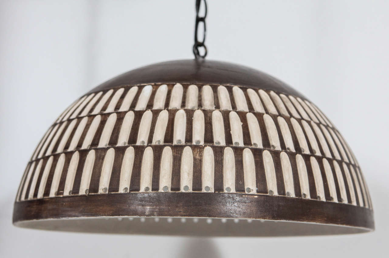 Beautiful round ceramic pendant with detailed perforations and copper / brass glaze. 45