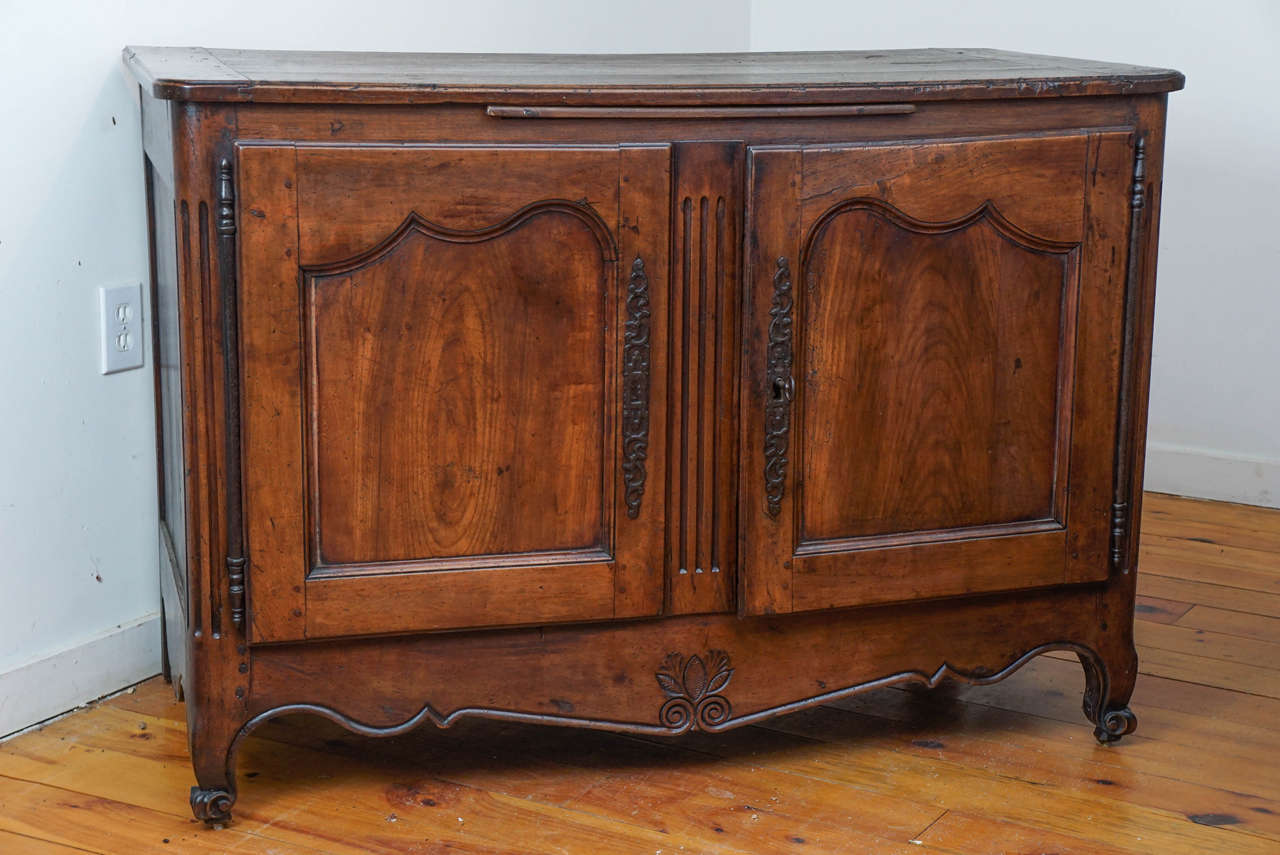 One of our personal favorites is this very early French cherry buffet. It is completely original. It has beautifully shaped panels on its two door front, three flutes embellish the center column, its shapely cabriole legs have turned up 