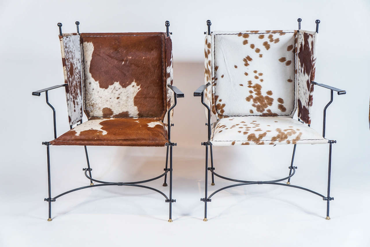 Brown and white cowhide upholstery over a welded iron frame. Arm height: 27