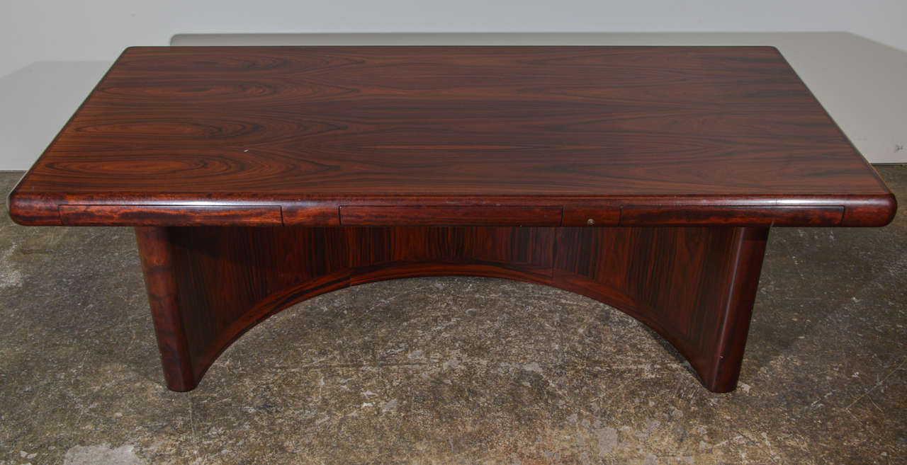Super Skyline Executive Desk by Dyrlund. This demi-lune, base, rosewood desk is in great condition. The desk drawers are hidden with built-in trays for a seamless design.