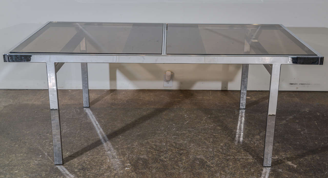 This Milo Baughman dining table is in good condition. The top panels side to reveal a center leaf to expand table.