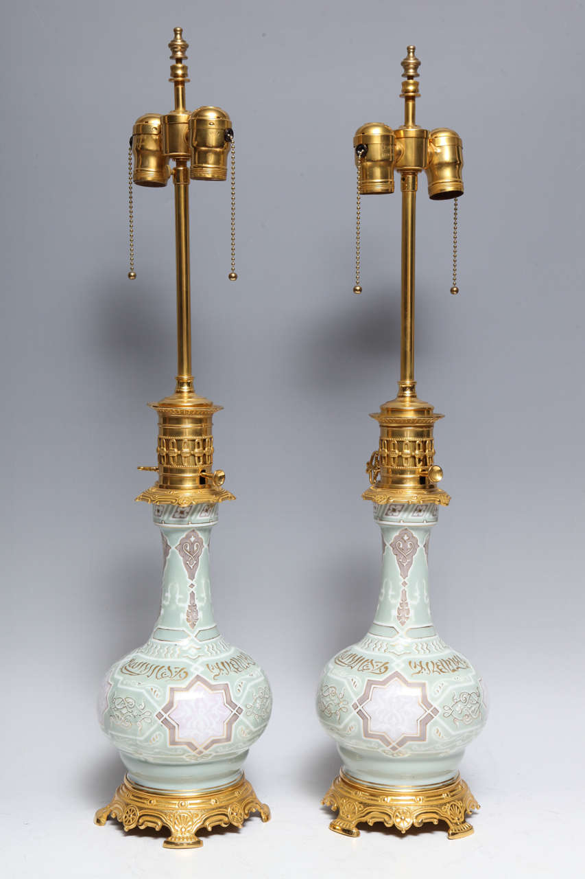 A fine and quite unusual pair of antique French ormolu-mounted Pate Sur Pate porcelain vases, beautifully decorated in the orientalist motif, originally mounted as oil lamps, still having the original oil lamp fittings. Each vase decorated in the