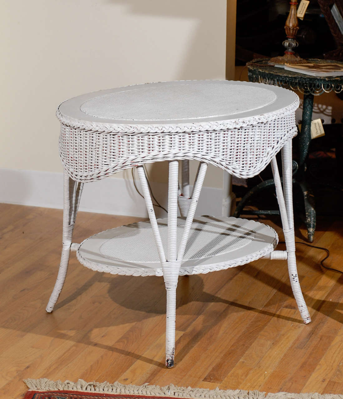 This is a wonderful Bar Harbor table.  The wavy apron can be seen from all angles.  There is a shelf with an woven center.  The table has a braid edge and wrapped legs.  This is a fantastic piece of Americana.