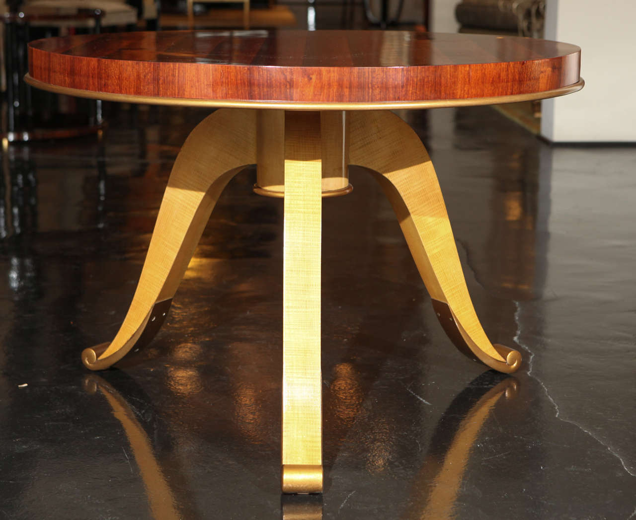 Coffee table with  rosewood veneer top. Raised on three curved legs in fruitwood. Gold-leaf detailing on feet and border surrounding the top. Continental height coffee table or larger side table.
