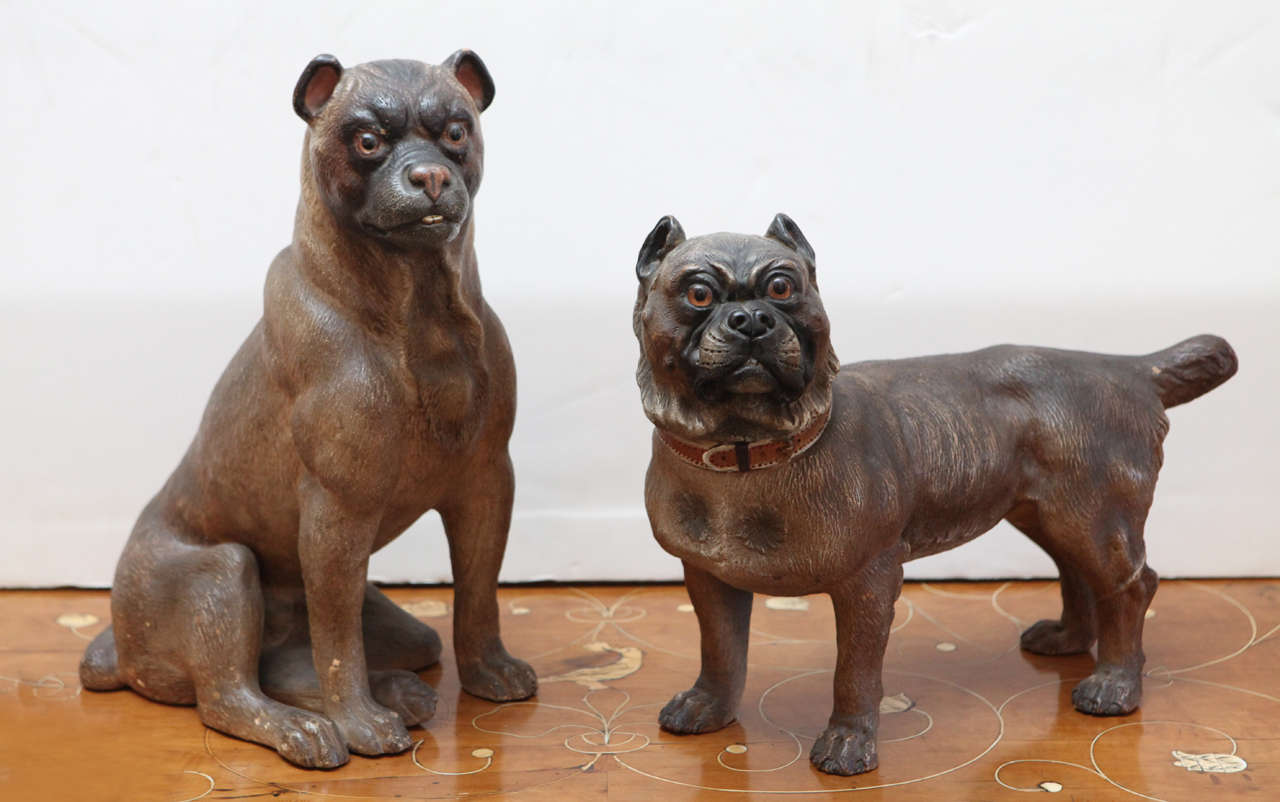 Pair of expressive, hand-painted, terracotta dogs with glass eyes from England.