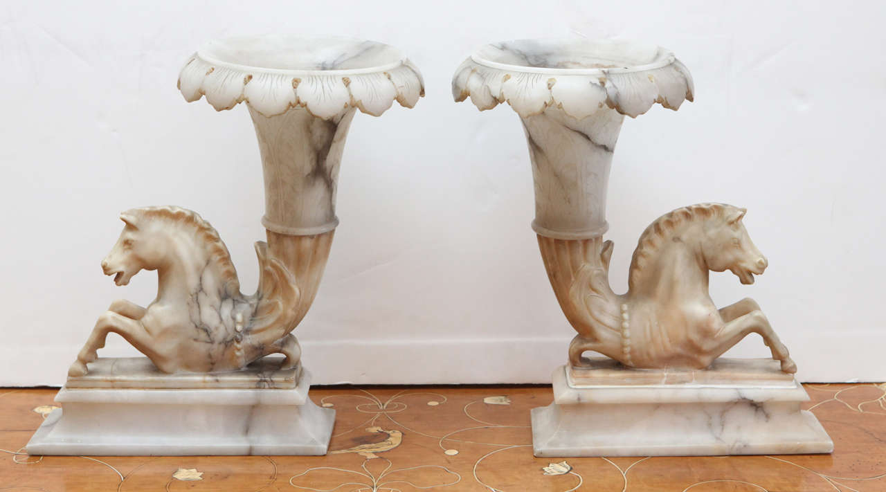 Dramatic pair of Grand Tour period, hand-carved, alabaster, left and right, foliate rim cornucopia vases featuring hippocampi.