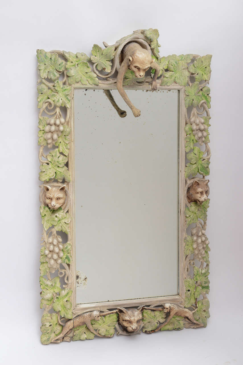 Fantastical carved wood mirror with monkey and cat motif.