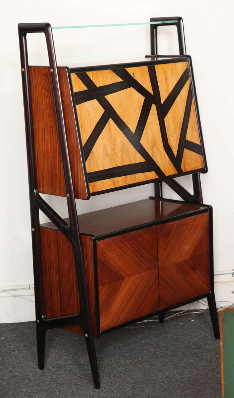 Very stylish liquor cabinet design by Dassi made in Milan 1950. Rosewood with ebony marquetry design on the drop front door, beautiful organic side supports, great small narrow cabinet.
 