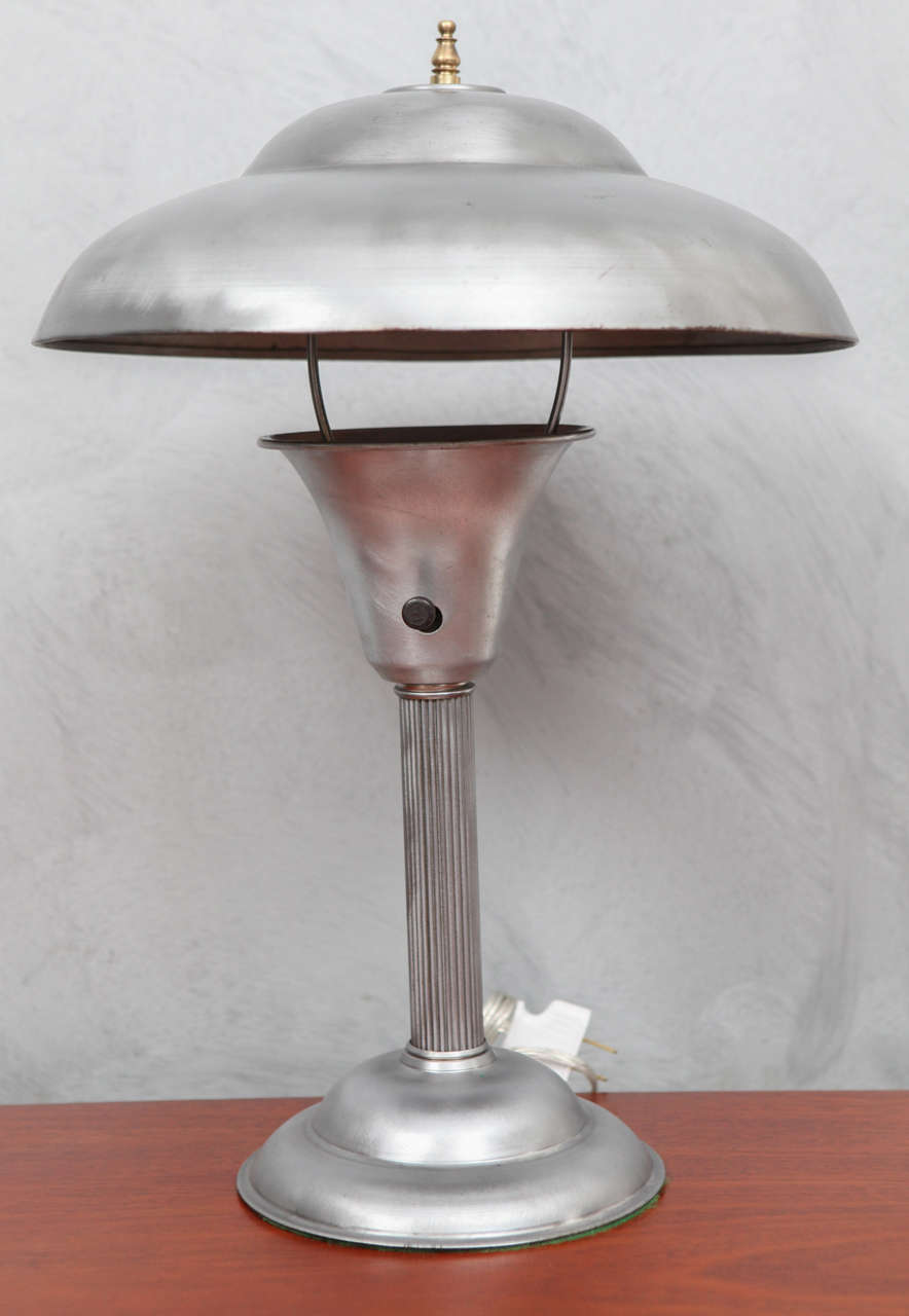 We love these American Art Deco streamlined style lamps that are such great examples of the simple elegance of the period. The floating saucer shade is suspended with the harp and tipped with a brass filial. the lamp is in good vintage condition