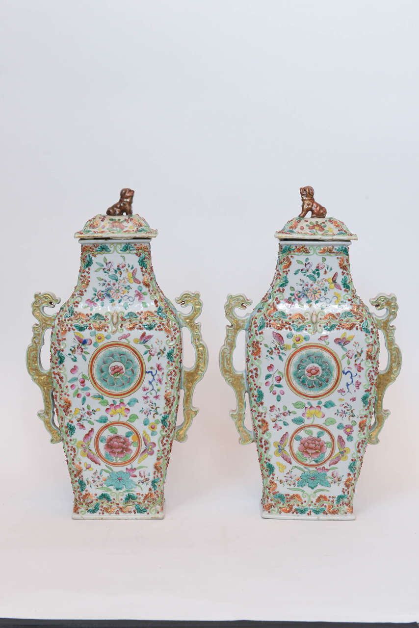 A rare and unusual large pair of Chinese porcelain vases with white ground geometric pattern paintings with raised leaves and berries, gold reticulated dragon handles and foo lion covered tops, circa 1760.