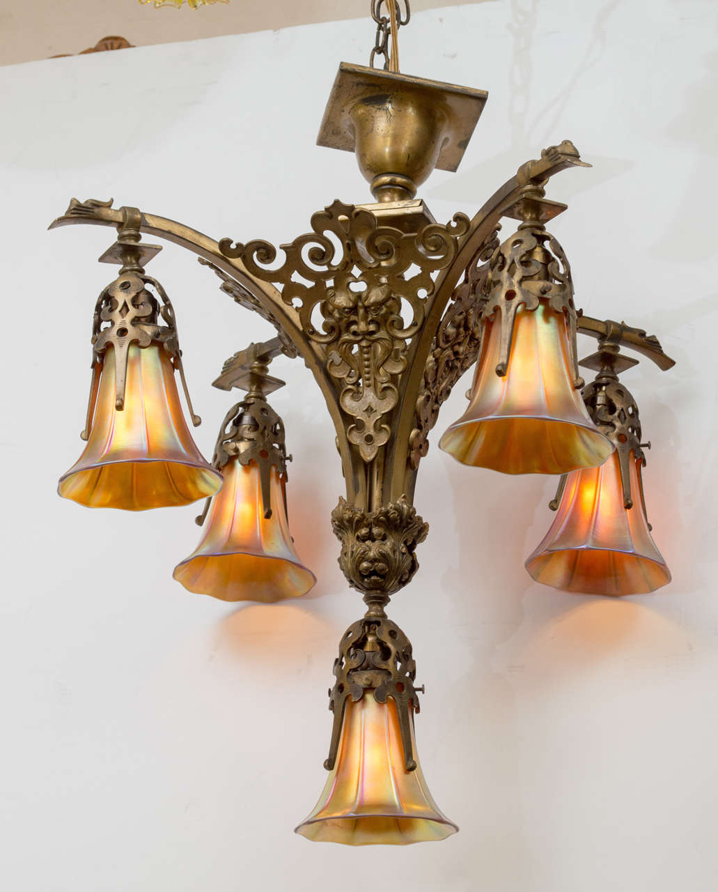 This very eye-catching chandelier is about quality. Detail castings, and original handblown art glass shades make this a wonderful package. Note the face in the center of the body as well as the little bearded faces on the top of the arms. We can