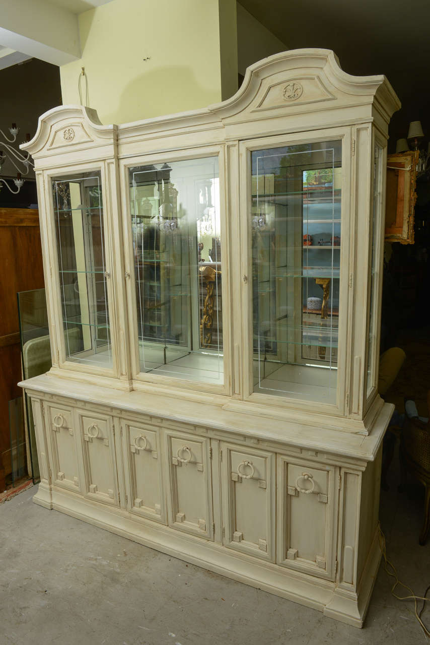 This is a very nice solid good display cabinet or showcase. There are light  to  the top for each section ,with mirrors to the back and beveled glass doors. The top comes off the base there are 3 drawers to the right open space.