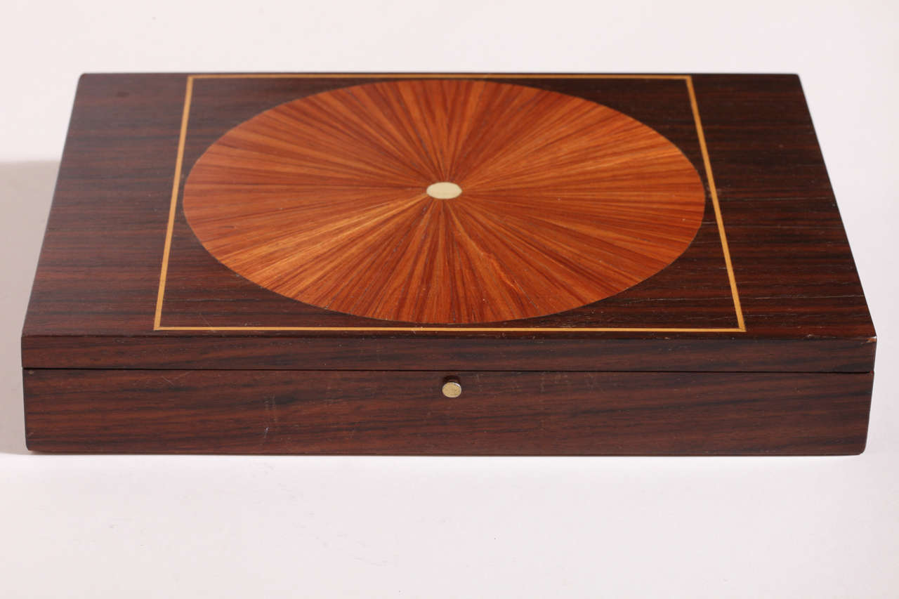 Palisander jewelry box inlaid with marquetry circle of exotic wood and bone. Interior lined in silk.