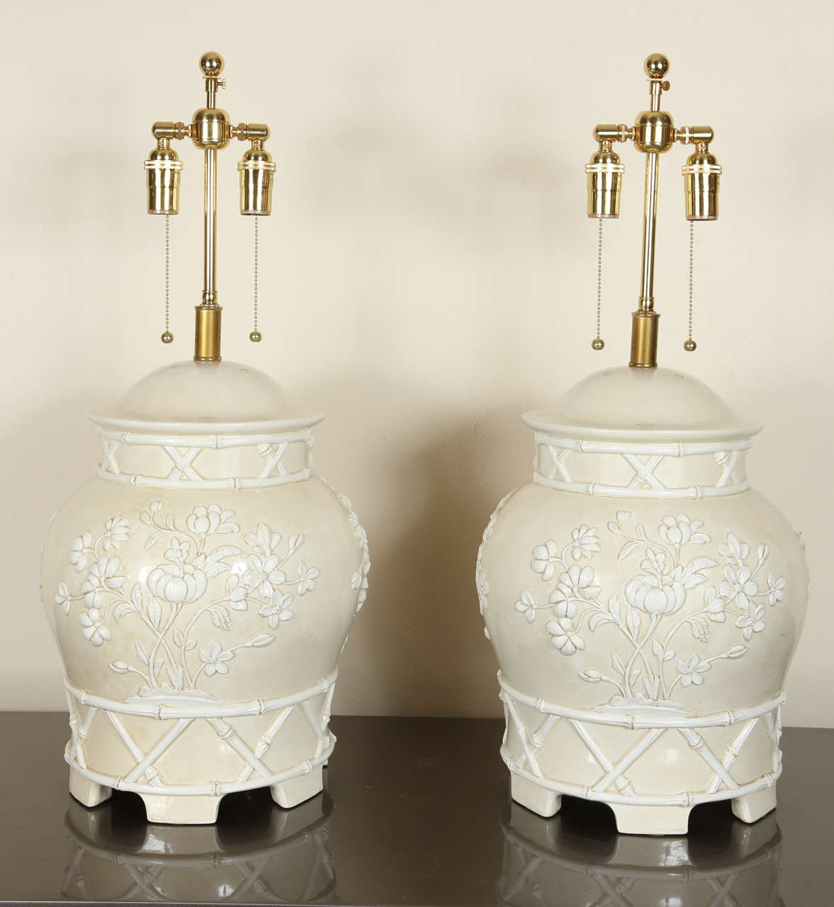 Pair of beautiful Italian ceramic table lamps.  They feature a bamboo basket work design and molded flowers.  They have a beige and white glaze. They are newly rewired and outfitted with brass double clusters.