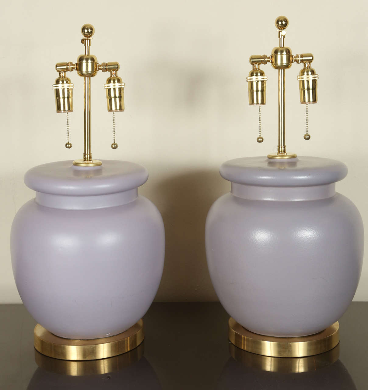 Pair of urn shaped table lamps with a lavender glazed finish.
The lamps are mounted on brass bases and they have been newly rewired with brass double clusters.