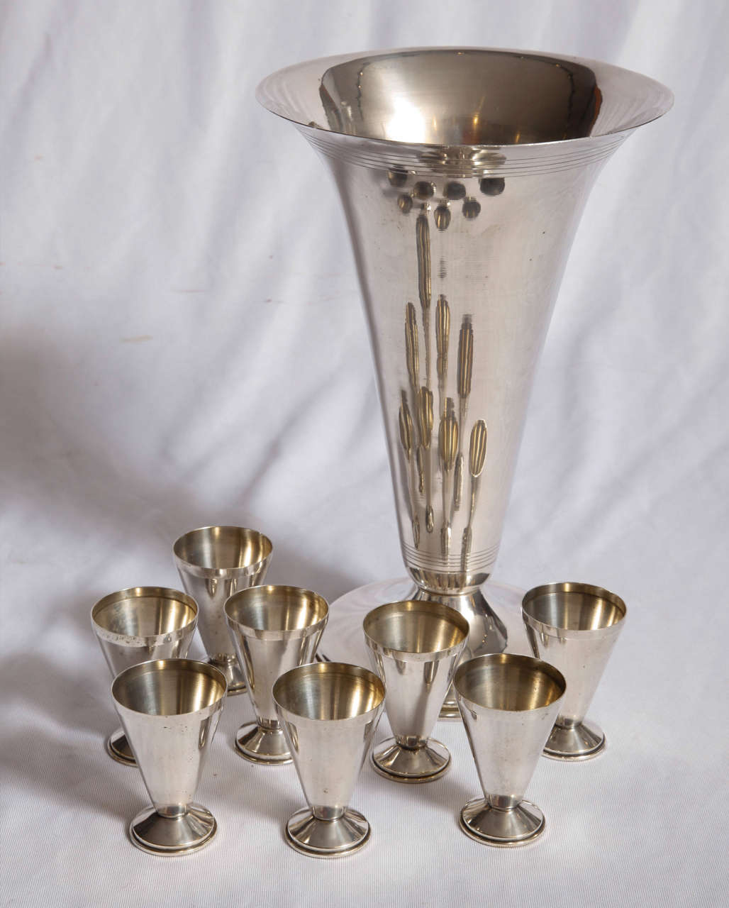 A set of eight silver plated cups and their bottle holder.