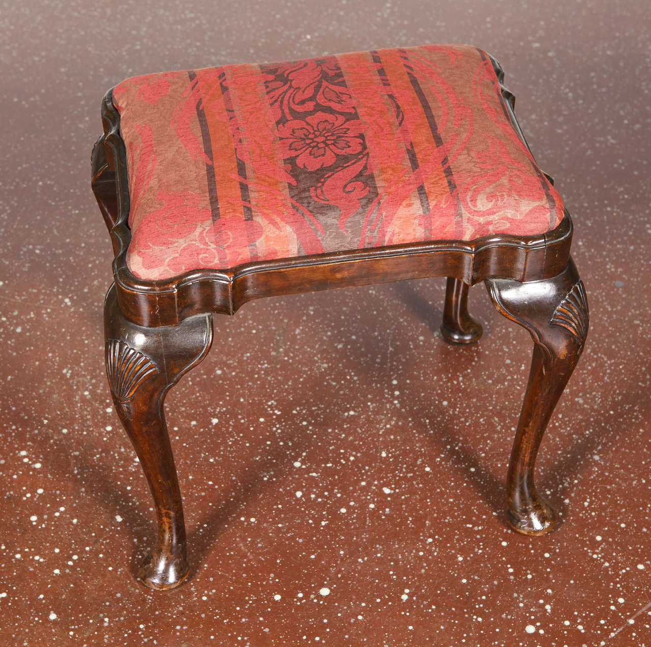 Georgian style footstool with shaped rectangular upholstered top, raised on cabriole legs with shell-carved knees.