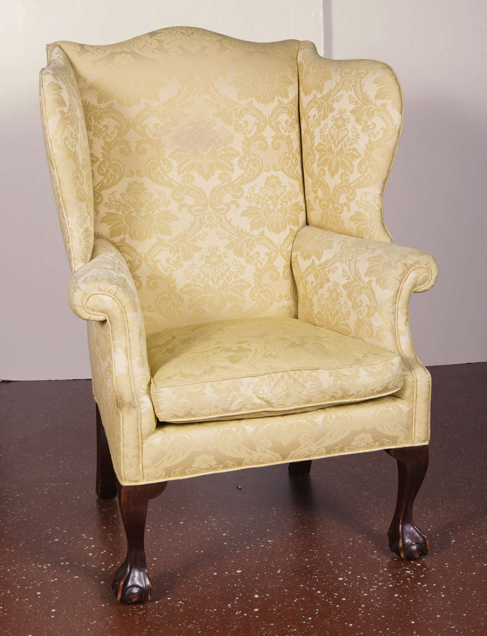 American Queen Anne style wing back armchair with cream damask upholstered back, arms & seat, cabriole legs with webbed ball and claw feet.  Circa 19th c.