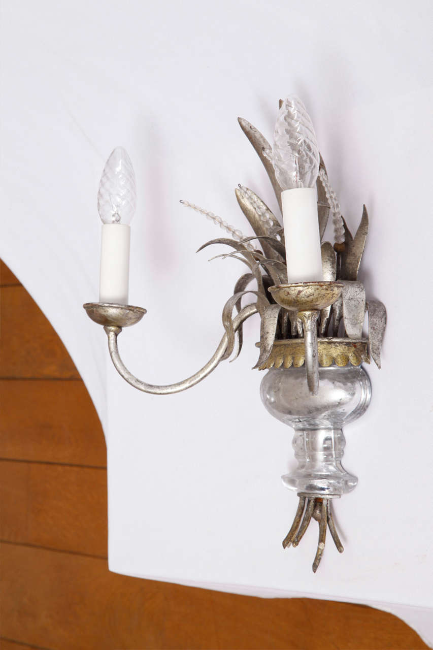 Decorative sconce in silvered and gilt metal and glass produced by Maison Baguès in Paris.