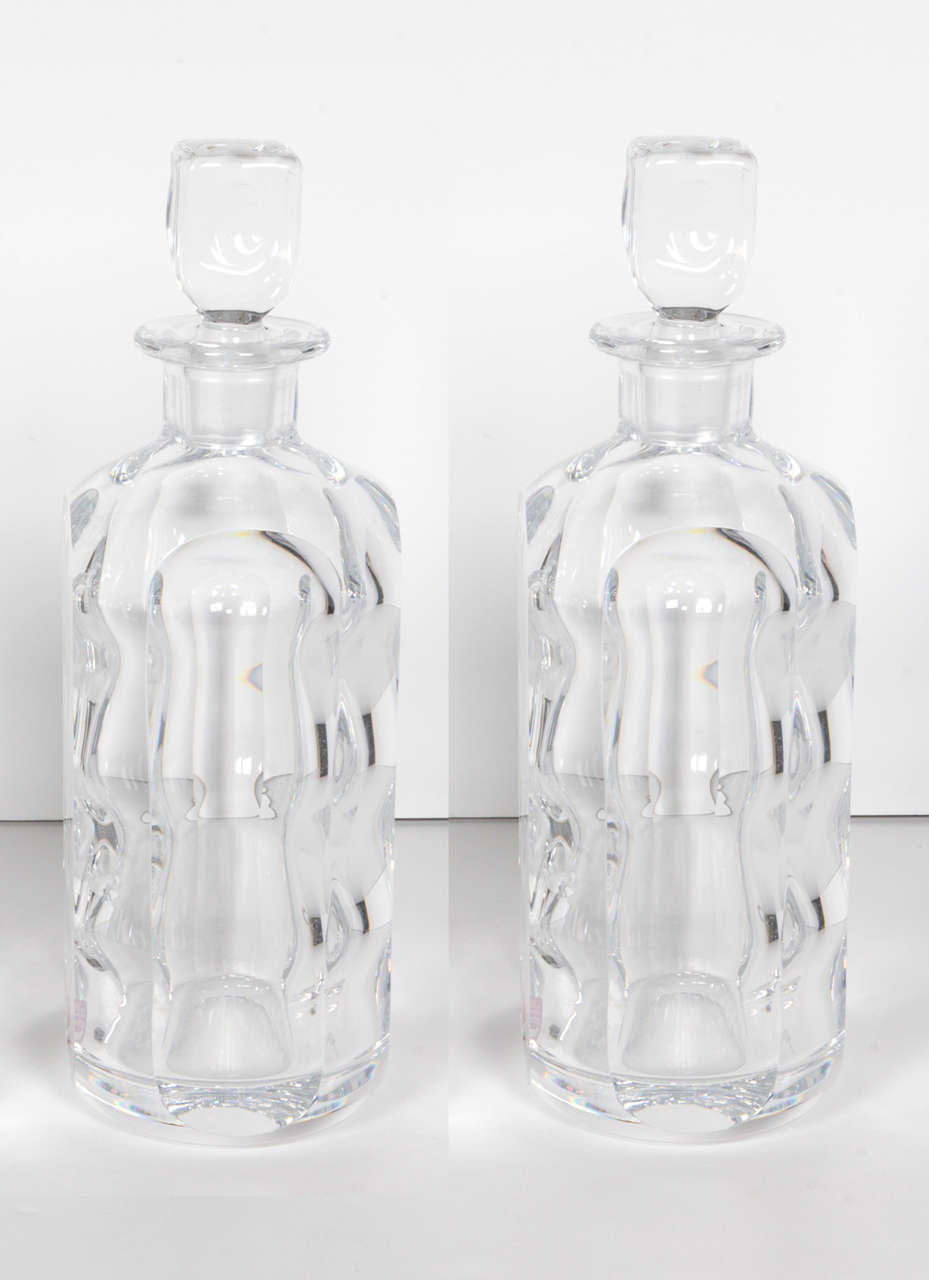 A beautiful pair of crystal decanters by Sven Palmqvist for Orrefors. The sculpted interior lends a unique visual dimension. Signed and numbered on bottom.
