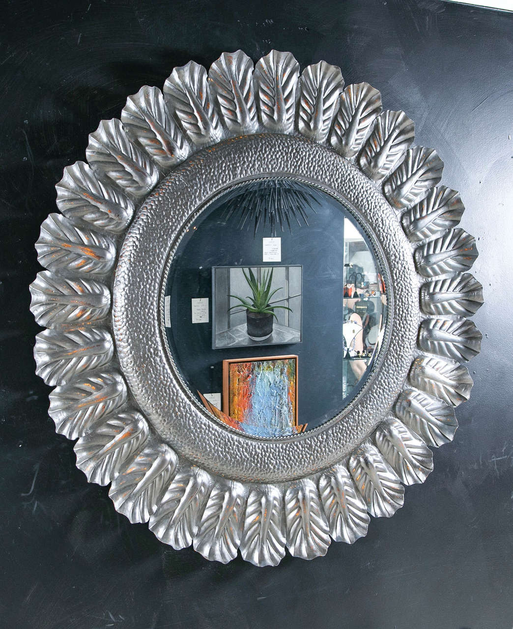 Mirror surrounded with painted ziaac leaves.