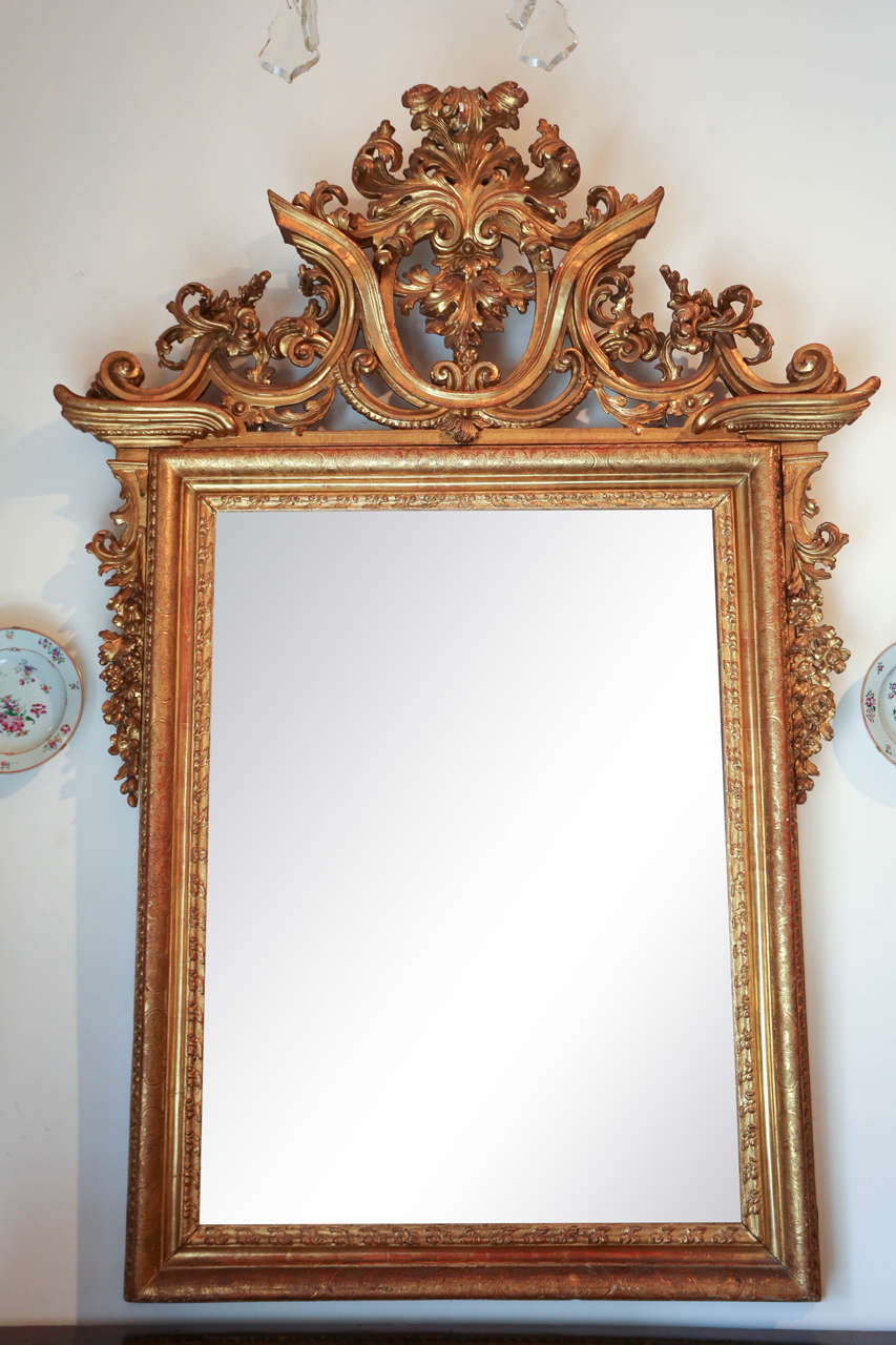 A very fine, large, gessoed and 22k gold gilded, carved Venetian mirror with elaborate, pierced crown surmounted by a scrolling acanthus leaf. The whole inset with newer glass.