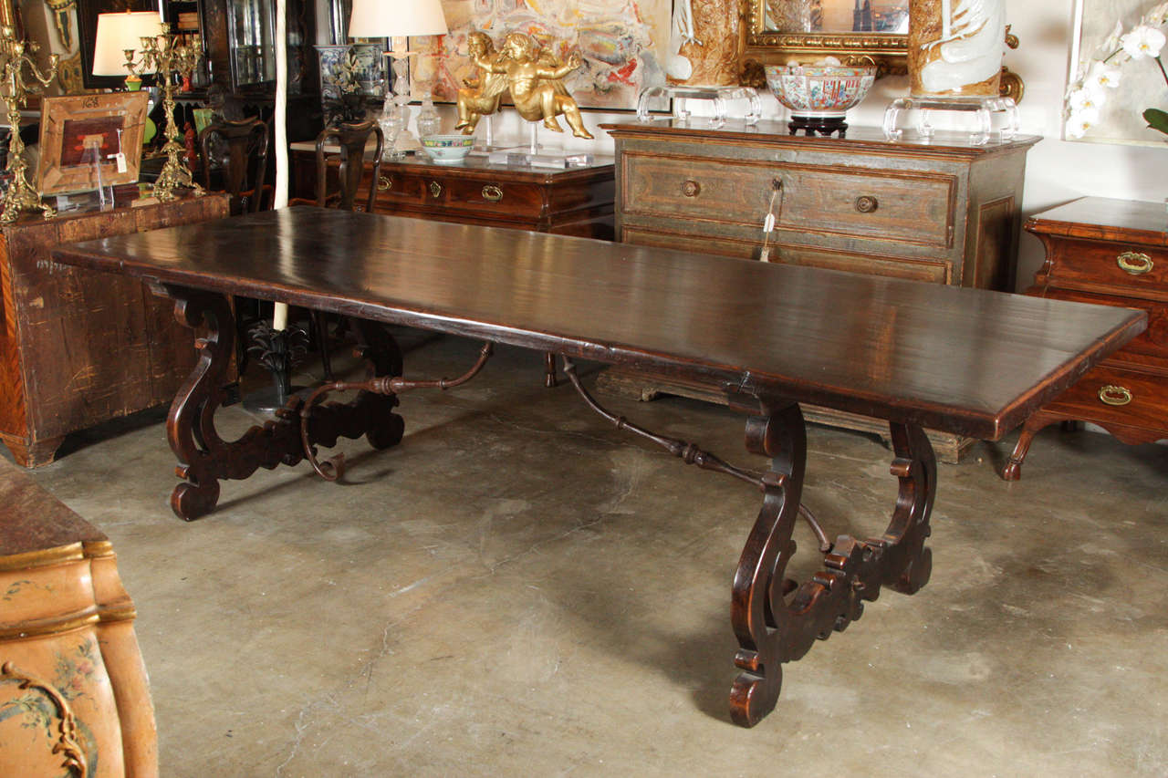 19th century, Tuscan, walnut trestle table with hand-cast, wrought iron stretcher.