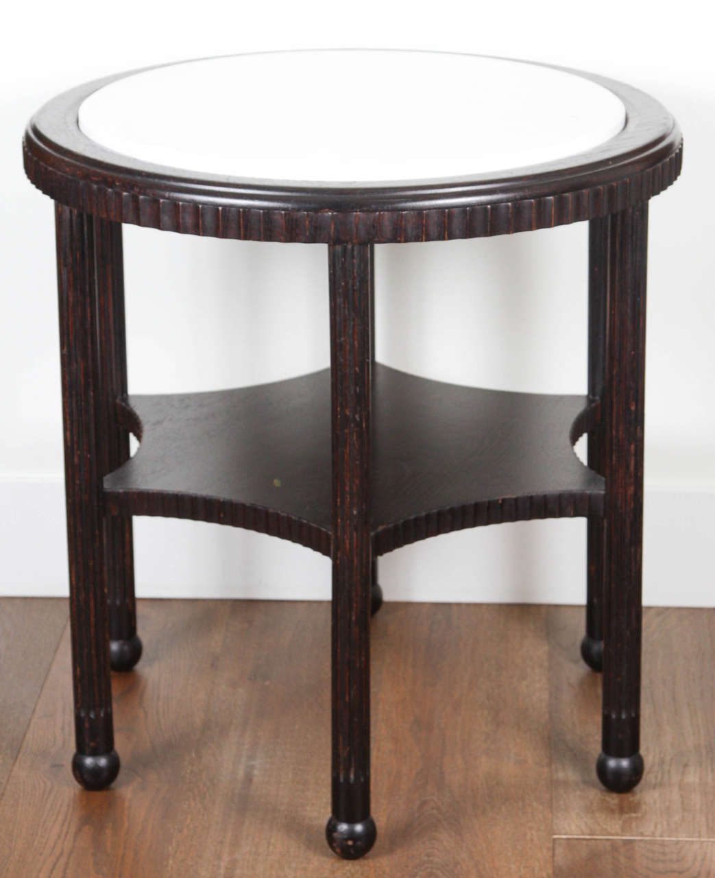 1970s round ebony stained side table with marble top, fluted apron and six legs supported on turned feet.