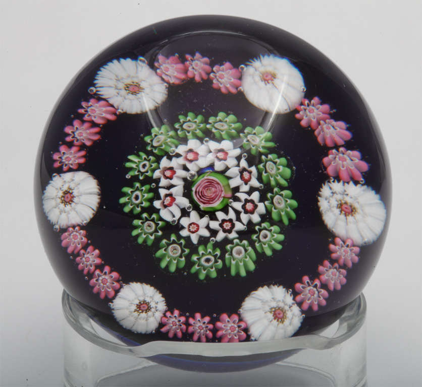 A fine antique Clichy spaced concentric millefiori paperweight on cobalt blue ground with central pink and green rose cane