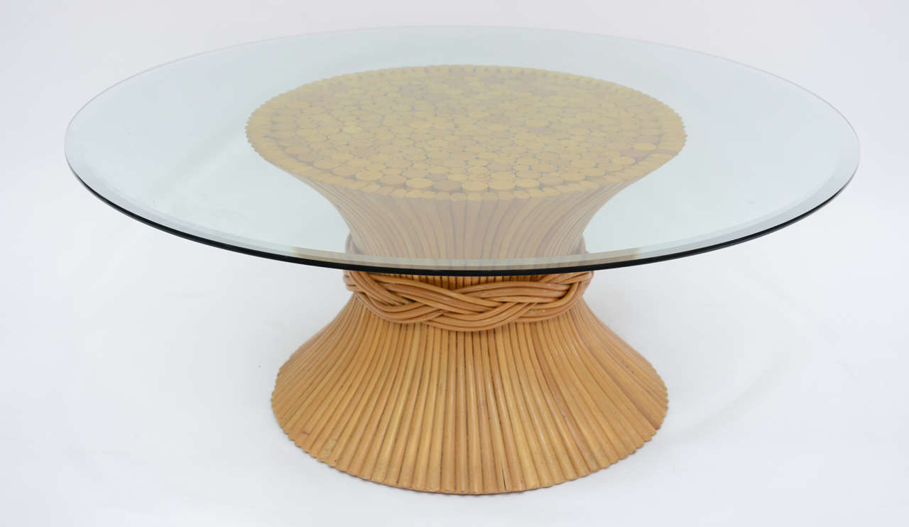 This beautiful Vintage Mid-Century coffee table made by McGuire from the 1960’s in the form of a bundled sheaf of wheat. Rattan shafts encircled by a decorative rattan tie and a round glass top. A smaller glass would also work well if you would to