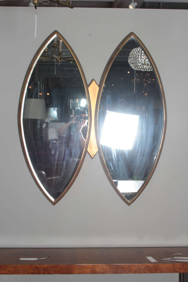 Two thin, deep carved wooden frames surround navette shaped mirror plates, the center joined by a shaped boss. Wonderfully patinated water gilt finish. By La Barge.

This item is located at our 1stdibs booth in the New York Design Center at 200