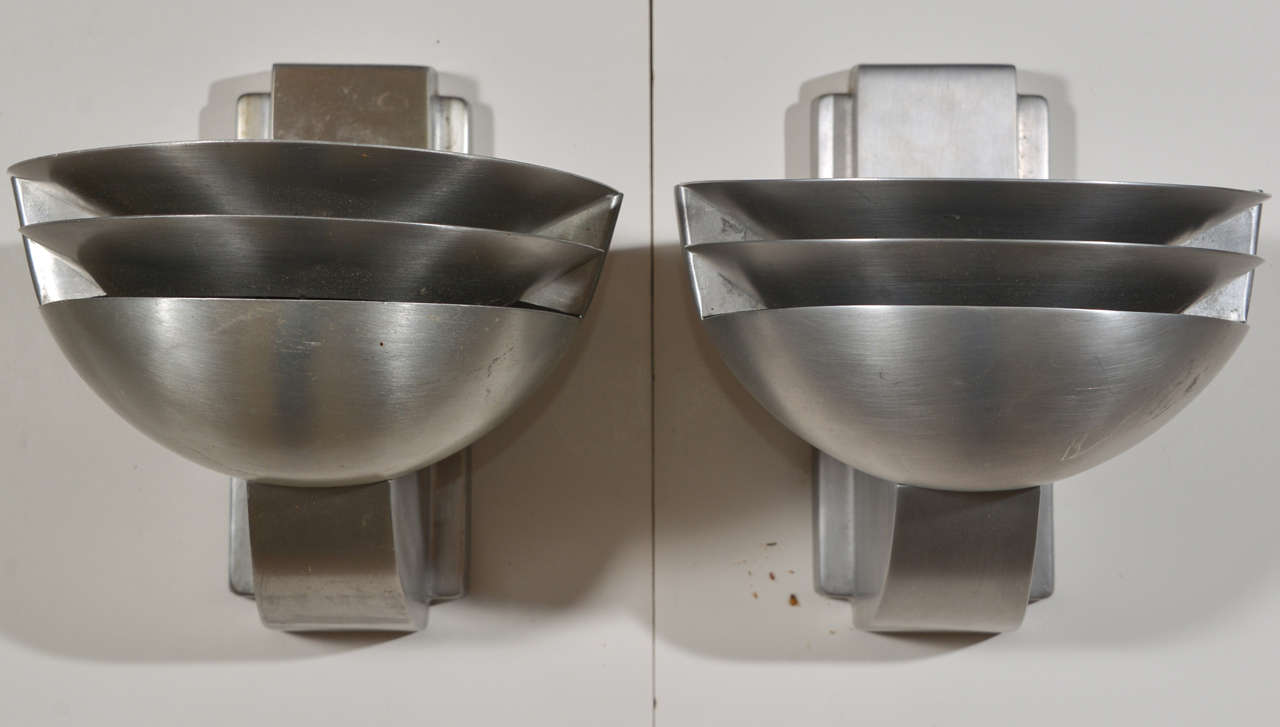 Pair streamline Rambusch sconces in original cast/spun aluminum, designed by Harold W. Rambusch.
Stamped RAMBUSCH U.S. PATENT 1,478,825
Structurally perfect, some wear to spun finish on bowls.  Common flaking to internal bowl black
