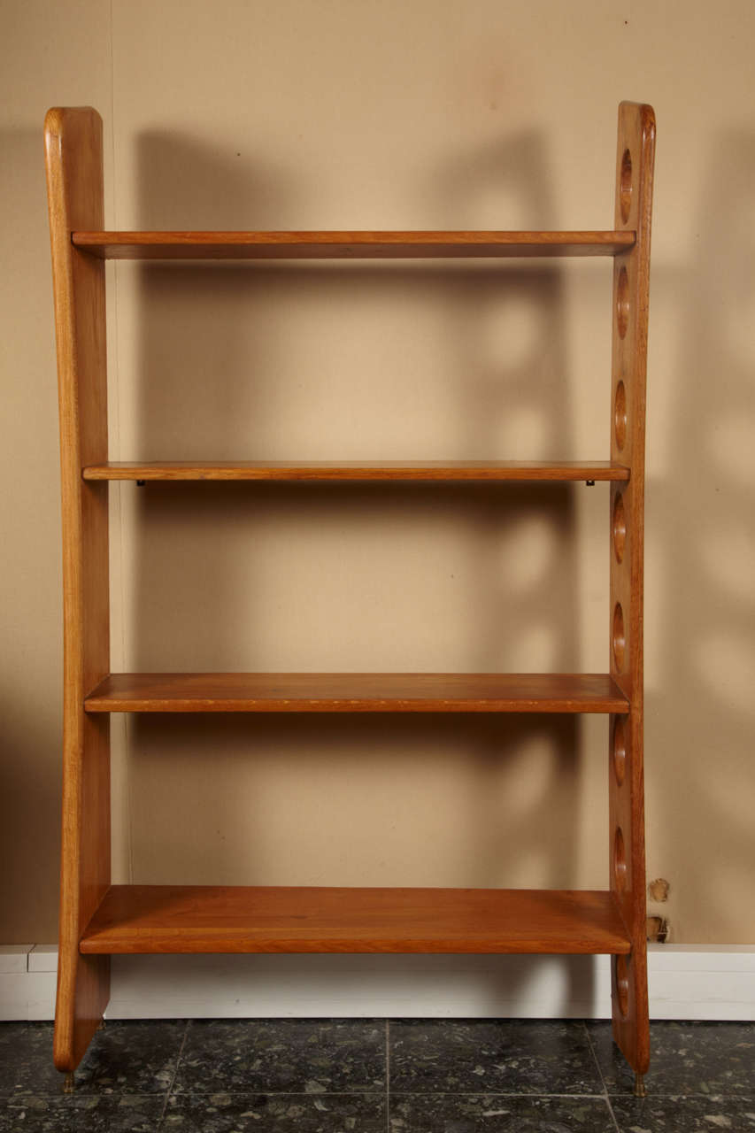 1950s asymmetrical bookcase by René Gabriel. Can be set on the floor with a  bronze system placed underneath, or can be hooked onto a wall with an iron system included into the side elements.