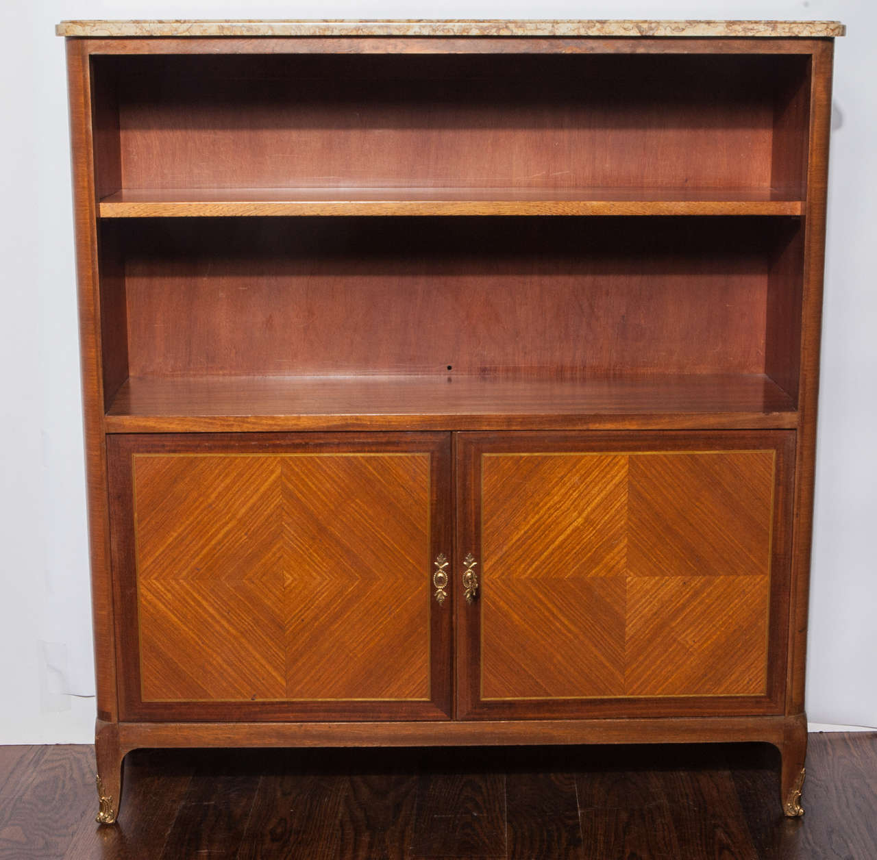 Bookshelf is mahogany with inlaid doors and side panels.  Two open shelves.  Doors open to reveal one additional shelf.  Bronze hardware.