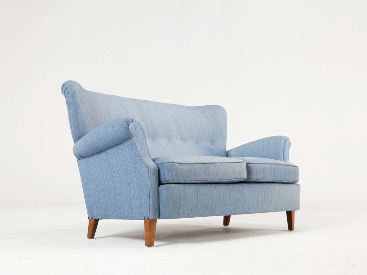 Scandinavian two-seater sofa upholstered in original blue wool fabric. 
Designed in the style of Carl Malmsten.

The back has deep-stitched buttons and the seat consists of two loose cushions. The armrests are elegantly shaped. The legs are made